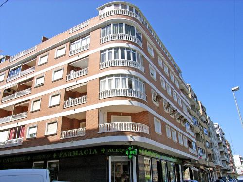 wysoki ceglany budynek z balkonami na ulicy w obiekcie Apartment Edificio Belen V by Interhome w mieście Torrevieja