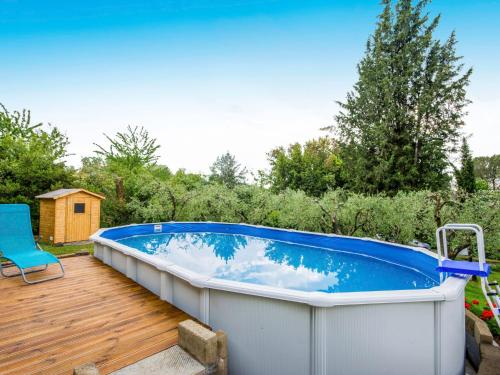 a hot tub on a deck with a blue chair at Holiday Home Il Fienile del Colle by Interhome in San Gennaro