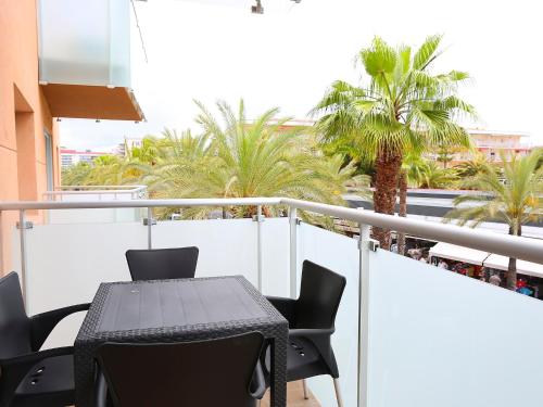 a table and chairs on a balcony with palm trees at Apartment Terecel Salou-6 by Interhome in Salou