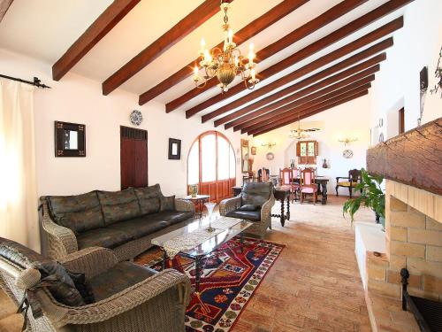 una sala de estar con sofás y una lámpara de araña. en Holiday Home El Baile Del Sol by Interhome en Pedramala