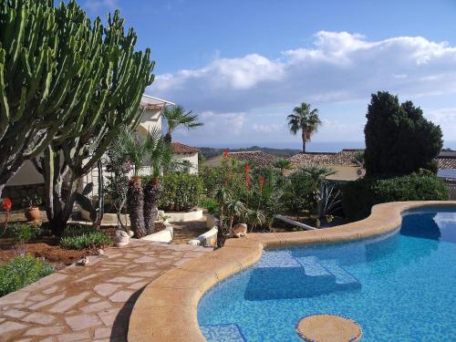 una piscina en un patio con árboles y una casa en Holiday Home La Caissa by Interhome, en Benitachell
