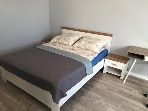 a bedroom with a bed and a table with a night stand at Goleniow Apartment in Gollnow