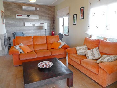 a living room with two orange couches and a table at Villa Corona by Interhome in Beniarbeig