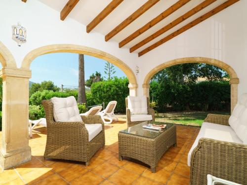eine Außenterrasse mit Korbstühlen und einem Tisch in der Unterkunft Holiday Home Tesoro Park by Interhome in Benitatxell