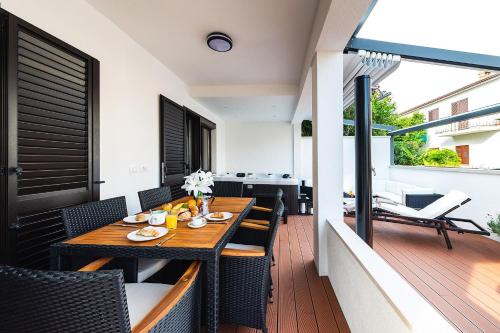 a wooden table and chairs on a balcony at Apartment Auretta in Novigrad Istria
