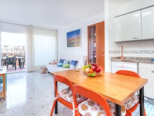 a kitchen and living room with a wooden table and chairs at Apartment Fleming by Interhome in Lloret de Mar
