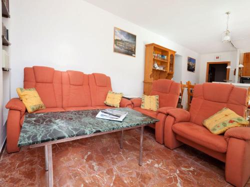 ein Wohnzimmer mit orangefarbenen Stühlen und einem Tisch in der Unterkunft Villa Villa Ute by Interhome in Les tres Cales