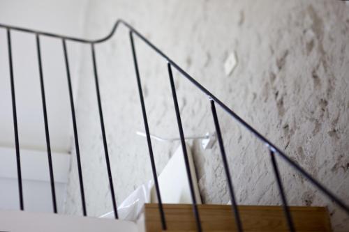 a set of stairs with black railings in front of a wall at Hotel Wu Wei in Kortrijk