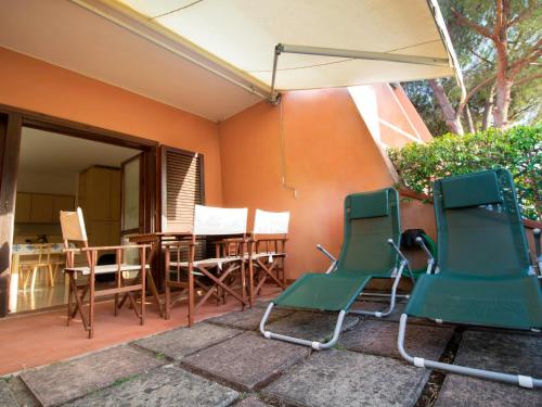 patio z krzesłami, stołem i parasolem w obiekcie Apartment Casina by Interhome w mieście Porto Azzurro