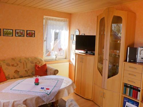 a small living room with a table and a tv at Apartment Bentweg by Interhome in Altgaude