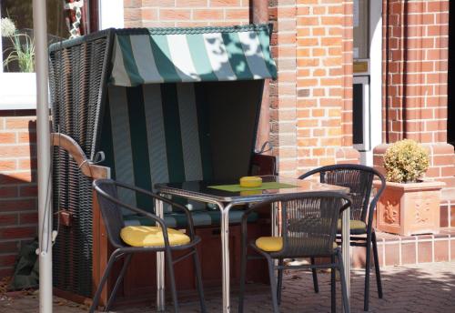 a table and chairs on a patio with an awning at Zum alten Bahnhof in Blunk