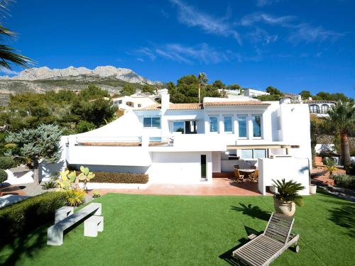 una casa blanca con un patio con césped verde en Villa Palm Spring by Interhome, en Altea la Vieja