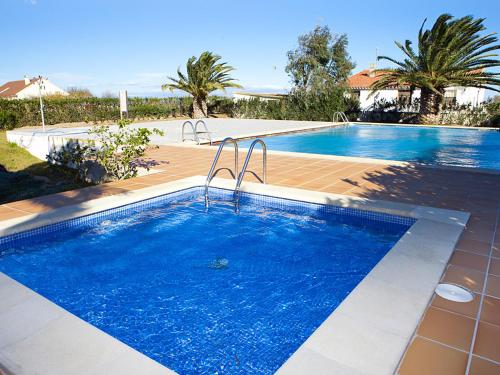 a large swimming pool with blue water in a yard at Apartment Royal Delta-4 by Interhome in Riumar