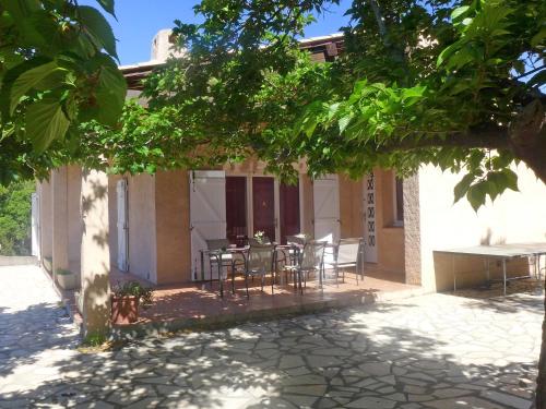 a house with a table and chairs under a tree at Holiday Home Roumagnac by Interhome in Cavalaire-sur-Mer