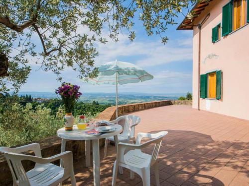 una mesa y sillas en un patio con sombrilla en Apartment Villa Morosi-1 by Interhome, en San Baronto