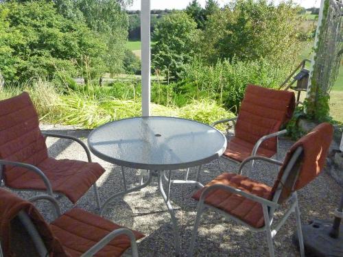 einen Glastisch und Stühle auf einer Terrasse in der Unterkunft Apartment Pusteblume by Interhome in Bleckhausen