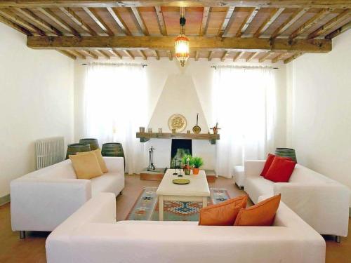 a living room with white couches and a fireplace at Villa Beboli by Interhome in Lamporecchio