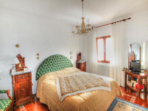 a bedroom with a bed with a green head board at Villa Villa Campo del Mulino by Interhome in Piteccio