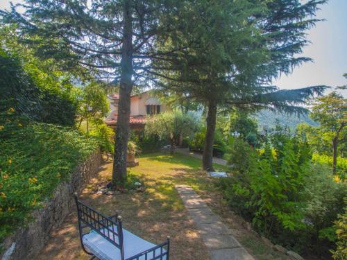 a bench in a garden with a house in the background at Villa Villa Campo del Mulino by Interhome in Piteccio