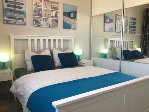 ソポトにあるMieszkanie 3 Majaのベッドルーム(青いシーツと鏡付きのベッド1台付)