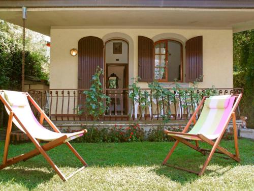 dos sillas sentadas en el césped frente a una casa en Villa Dea by Interhome, en Forte dei Marmi