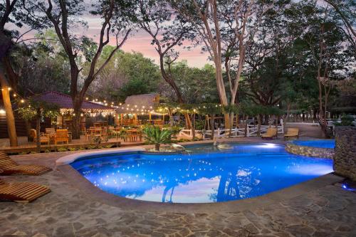 a pool at a resort with chairs and tables at Eco Casita 11 in Rivas