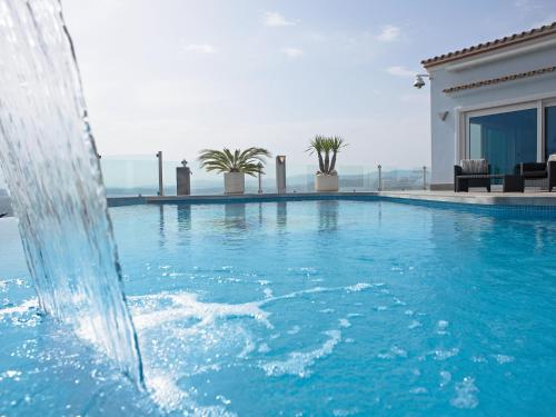 a swimming pool with a water fountain in front of a house at Holiday Home Finca Edel by Interhome in Cumbre del Sol
