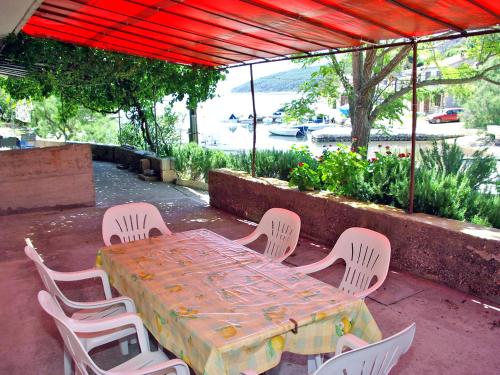 a table and chairs sitting under a red roof at Apartment Šarenko-1 by Interhome in Vela Luka