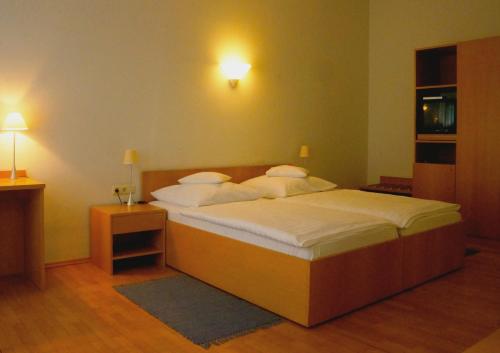 a bedroom with a bed with white sheets and pillows at Hotel zum Scheppen Eck in Wiesbaden
