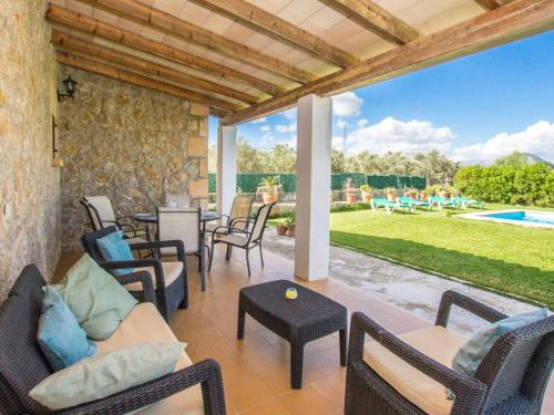 Un patio con sillas y una mesa y una piscina. en Holiday Home Can Mateu by Interhome, en Alcudia