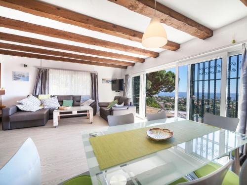 ein Wohnzimmer mit einem Glastisch und Stühlen in der Unterkunft Holiday Home Puig Romani-1 by Interhome in Platja  d'Aro