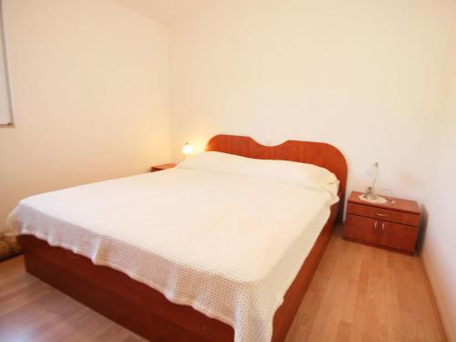a bedroom with a bed with a wooden headboard at Holiday Home Ratimir by Interhome in Rogač