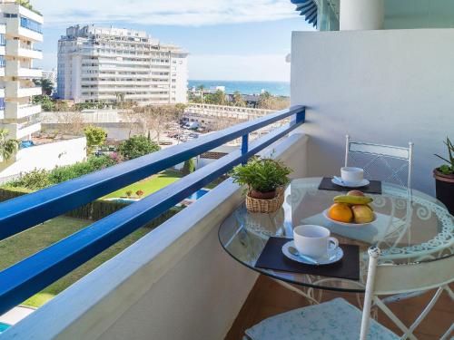 Apartment Las Terrazas by Interhome في مربلة: شرفة مع طاولة عليها مشروبات وفواكه