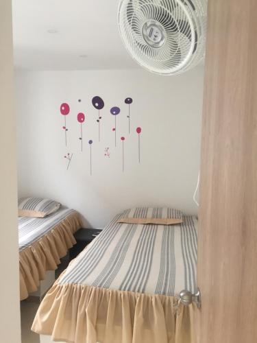 a room with two beds and a wall with clocks at Apartamento en el Eje Cafetero, La Tebaida in La Tebaida