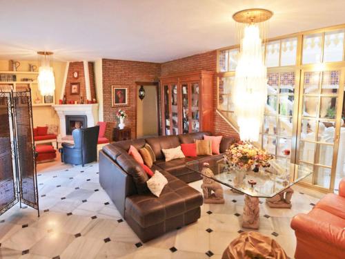 uma sala de estar com um sofá e uma mesa de vidro em Holiday Home La Poza by Interhome em Campanillas