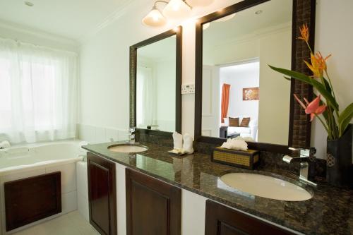 baño con 2 lavabos y espejo grande en Calabash Cove Resort and Spa - Adults Only, en Gros Islet