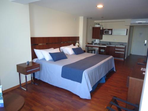 a bedroom with a large bed and a kitchen at Puerto Amarras Hotel & Suites in Santa Fe