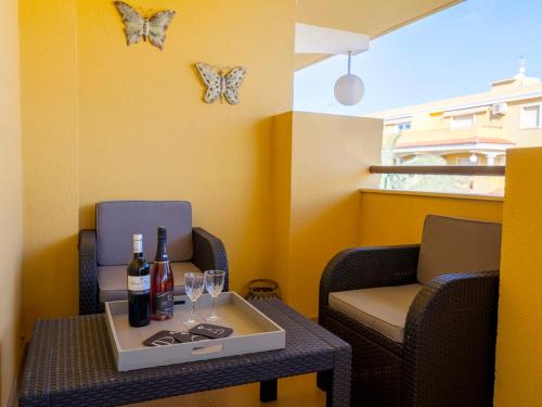 una mesa con dos botellas de vino y copas. en Apartment Cascadas de la Marina-2 by Interhome, en Denia