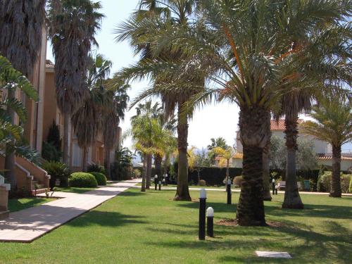 park z palmami obok budynku w obiekcie Apartment Keops by Interhome w mieście Casas Devesa