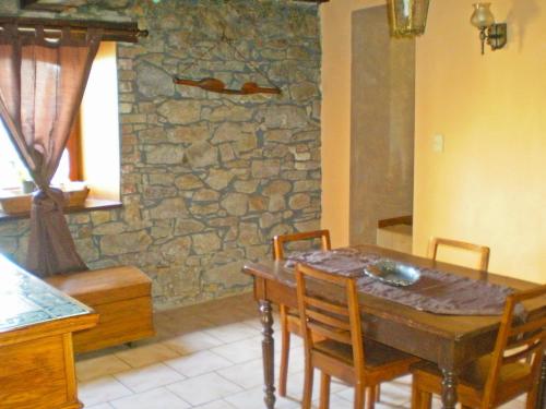 d'une salle à manger avec une table, des chaises et un mur en pierre. dans l'établissement Holiday Home Ma Campagne by Interhome, à Trois-Ponts