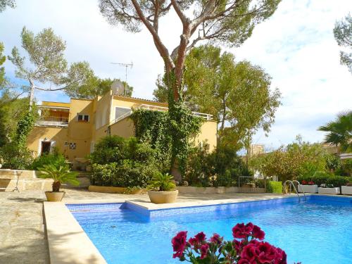 a swimming pool with flowers in front of a house at Villa Santa Ponça by Interhome in Santa Ponsa