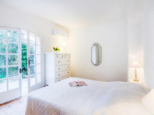 une chambre blanche avec un lit blanc et une fenêtre dans l'établissement Holiday Home Le Pilon by Interhome, à Saint-Tropez