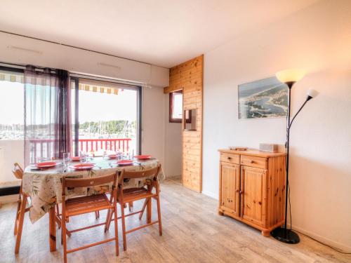 une salle à manger avec une table et une grande fenêtre dans l'établissement Apartment Le Grand Pavois by Interhome, à Capbreton