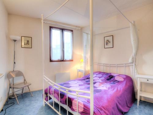 - une chambre avec un lit à baldaquin et une couette violette dans l'établissement Apartment Le Grand Pavois by Interhome, à Capbreton