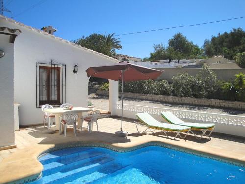 a patio with a table and an umbrella next to a pool at Holiday Home Heidi by Interhome in Empedrola