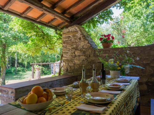 - une table avec un bol de fruits et des bouteilles de vin dans l'établissement Holiday Home Il Mulino di Cecco by Interhome, à La Ville