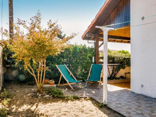 two blue lawn chairs sitting on a patio at Holiday Home Remember by Interhome in Mimizan-Plage