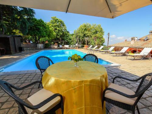 a yellow table with chairs next to a swimming pool at Villa Villa Mina by Interhome in Monte Compatri