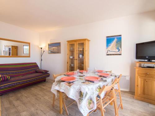d'une salle à manger avec une table, des chaises et une télévision. dans l'établissement Apartment Le Grand Pavois by Interhome, à Capbreton