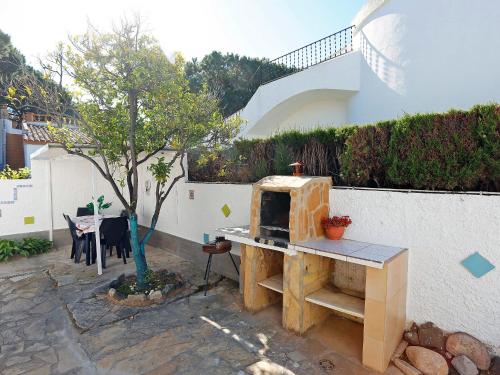 a patio with a pizza oven next to a house at Holiday Home Solimar Cambrils by Interhome in Cambrils